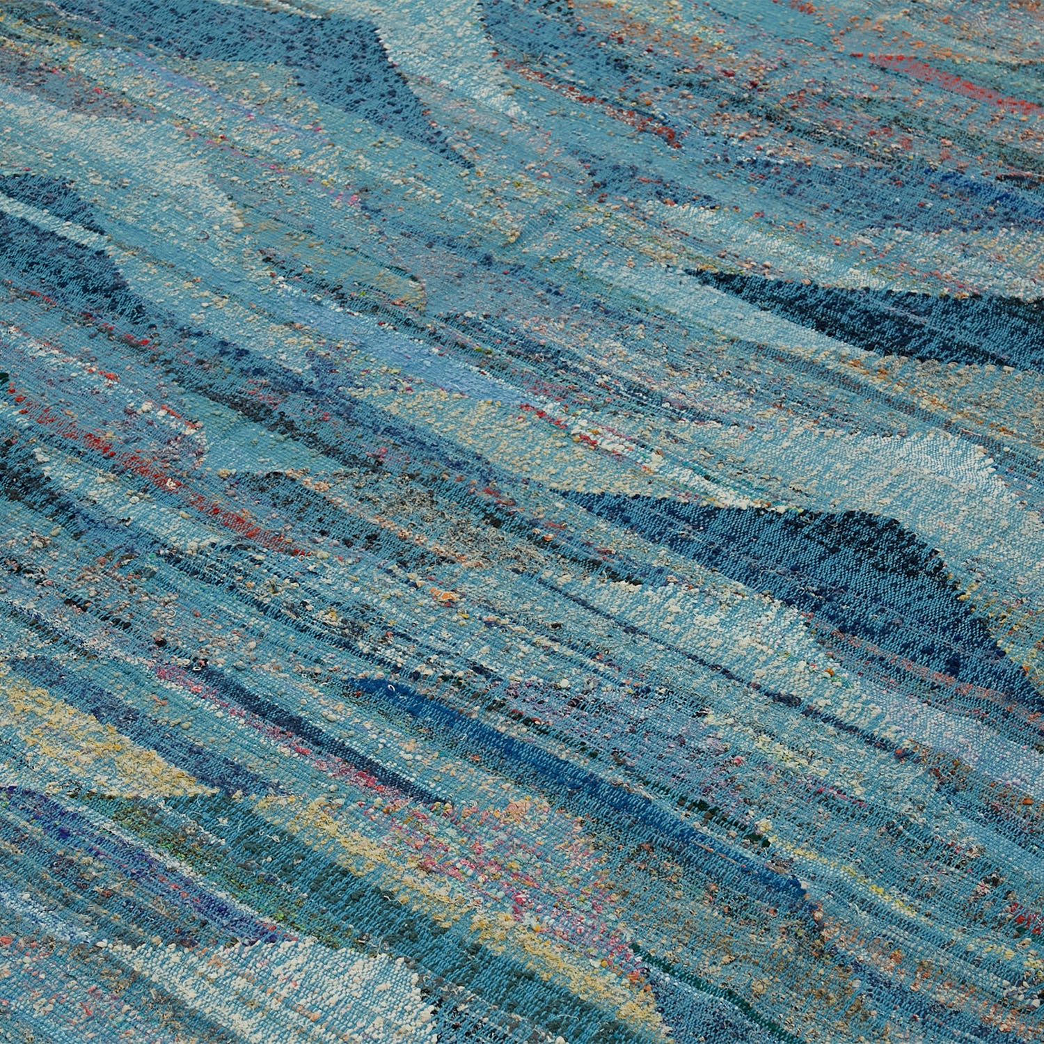 Close-up of a textured blue fabric with streaks of color.