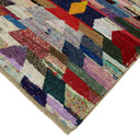 Vibrant and textured rug with colorful patchwork design and binding.