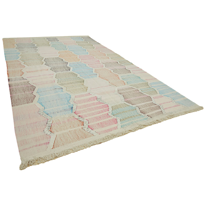 Rectangular area rug with pastel hexagon pattern on neutral background.