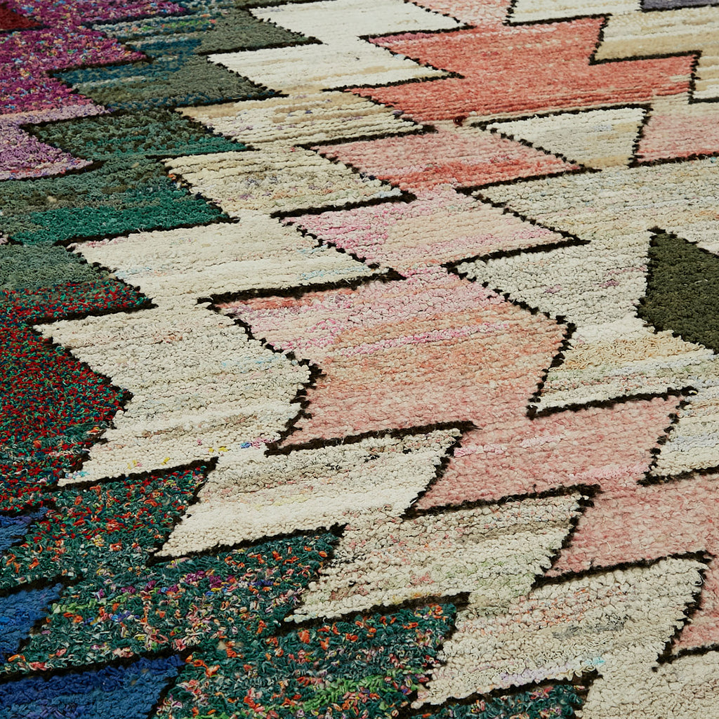 Close-up of vibrant, geometric rug showcases intricate design and texture.