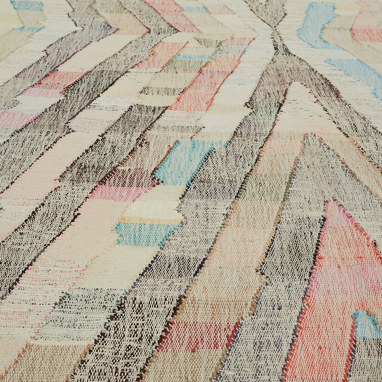 Close-up of intricately woven fabric with dynamic herringbone-like pattern.