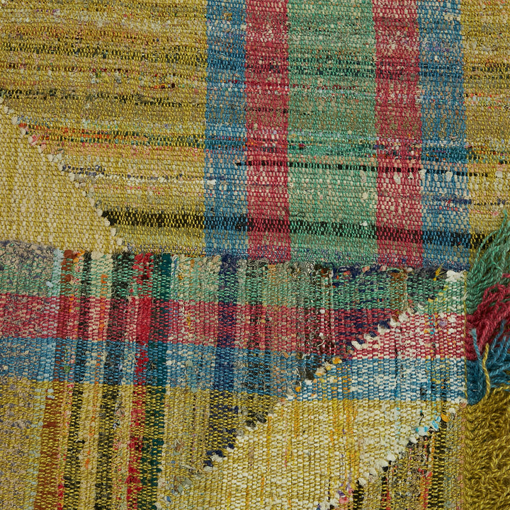 Vibrant, multicolored handwoven textile with visible texture and loose threads.