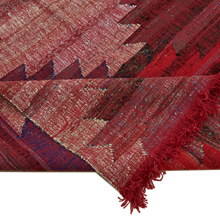 Close-up of a red woven textile with geometric zigzag pattern.