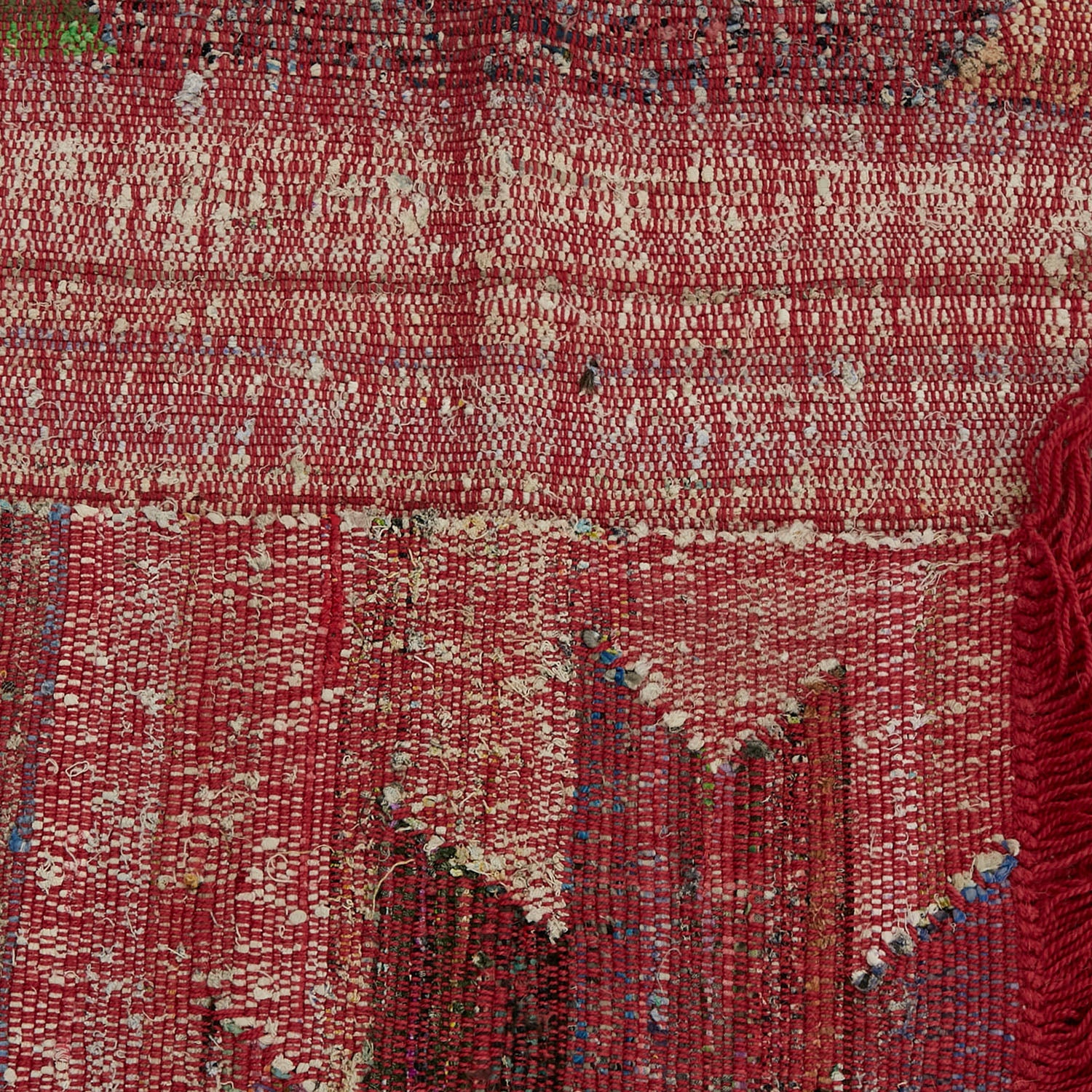 Close-up of red, white, and blue mottled fabric with fringed edge.