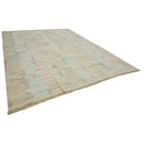 Modern distressed area rug with pastel colors and geometric motif.