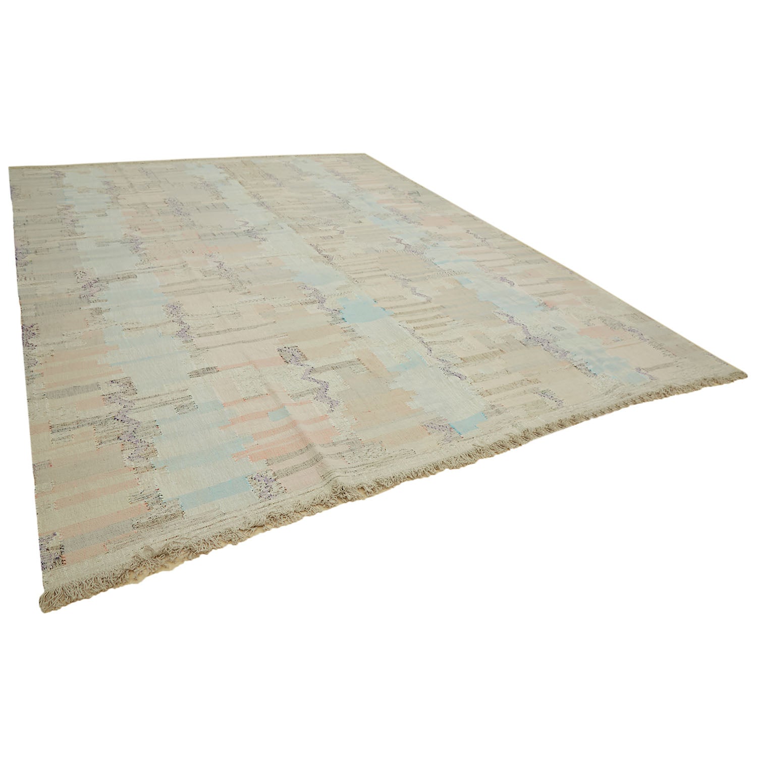 Modern distressed area rug with pastel colors and geometric motif.