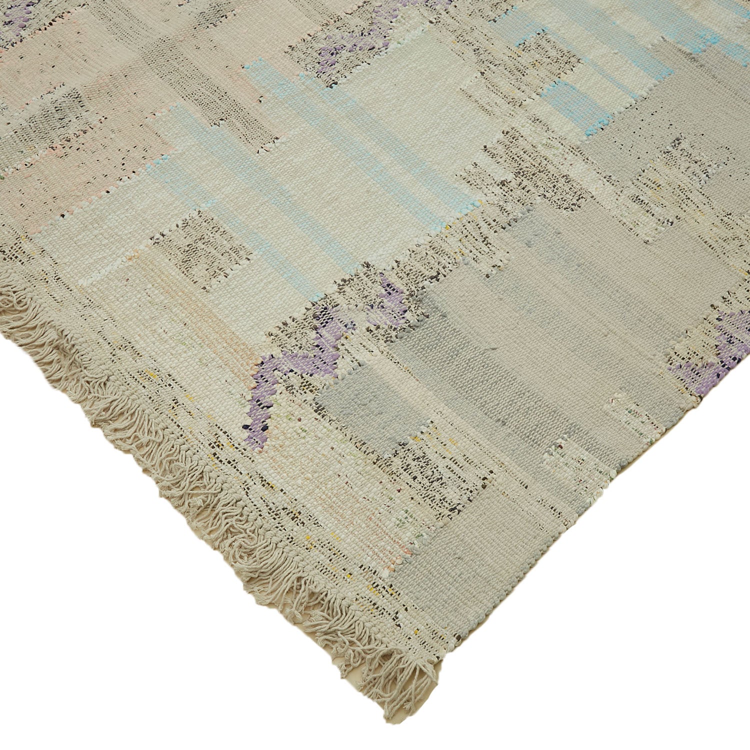 Distressed vintage rug with fringe in various earthy tones.