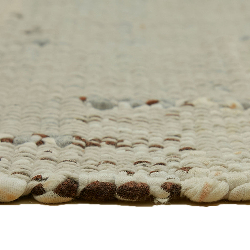 Close-up of textured woven fabric with cream and brown pattern.
