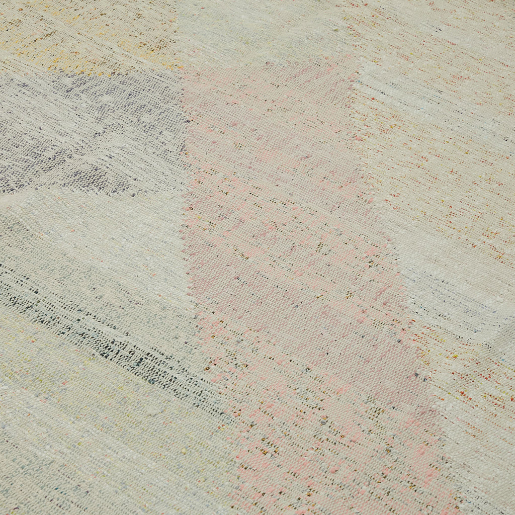 Close-up of multicolored, textured fabric with speckled design and visible weave.