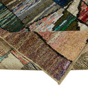 An eclectic stack of rugs displaying diverse colors, patterns, and textures.