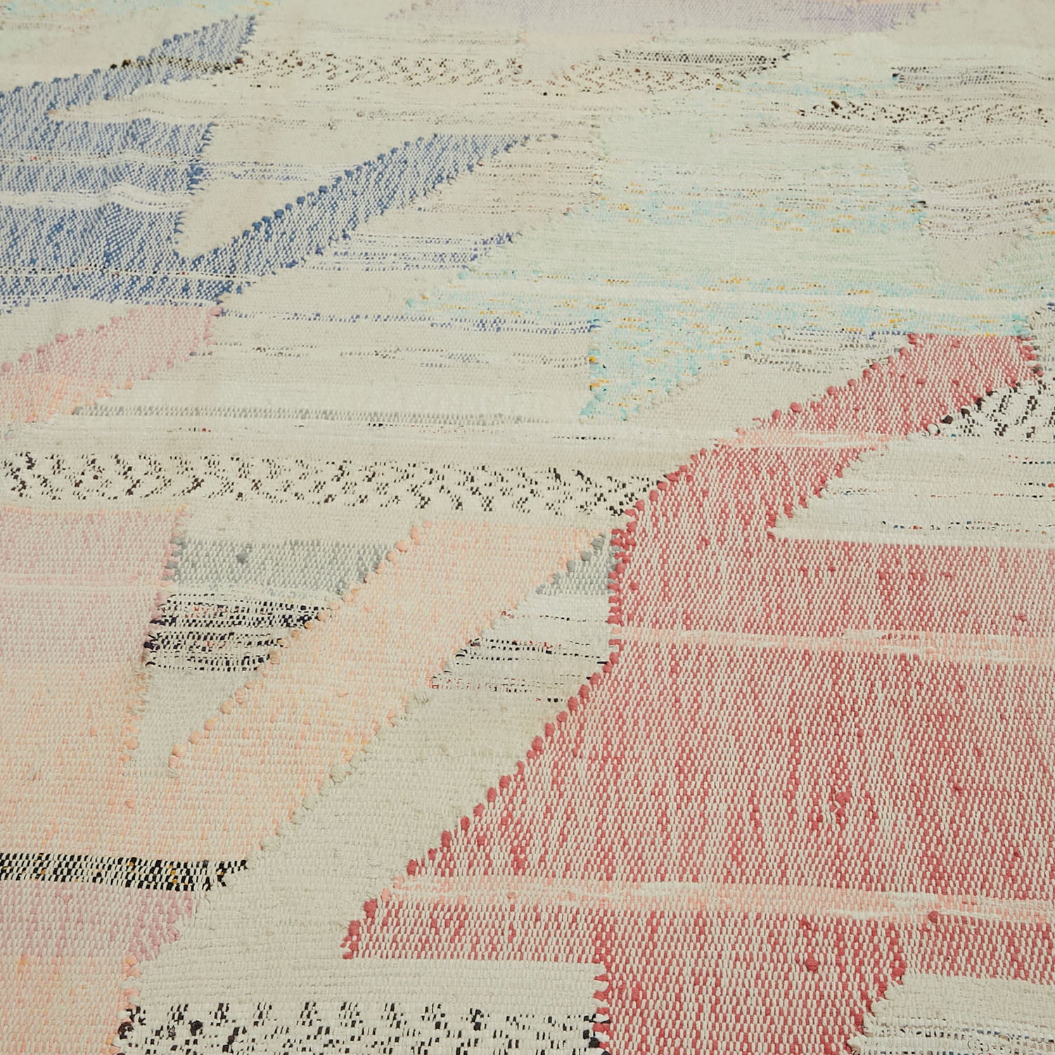 Close-up of vibrant, textured rug with dynamic geometric pattern.