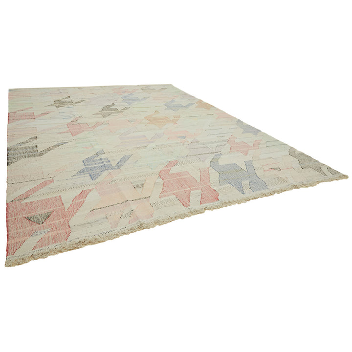 Large flat-laid rug with geometric pattern in pastel shades.