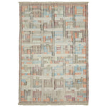 Intricate and abstract handcrafted rug with muted colors and fringe.