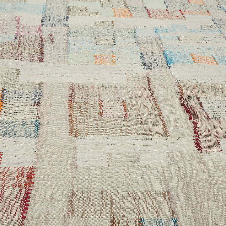 Close-up of a handwoven, textured rug with vibrant pastel colors.