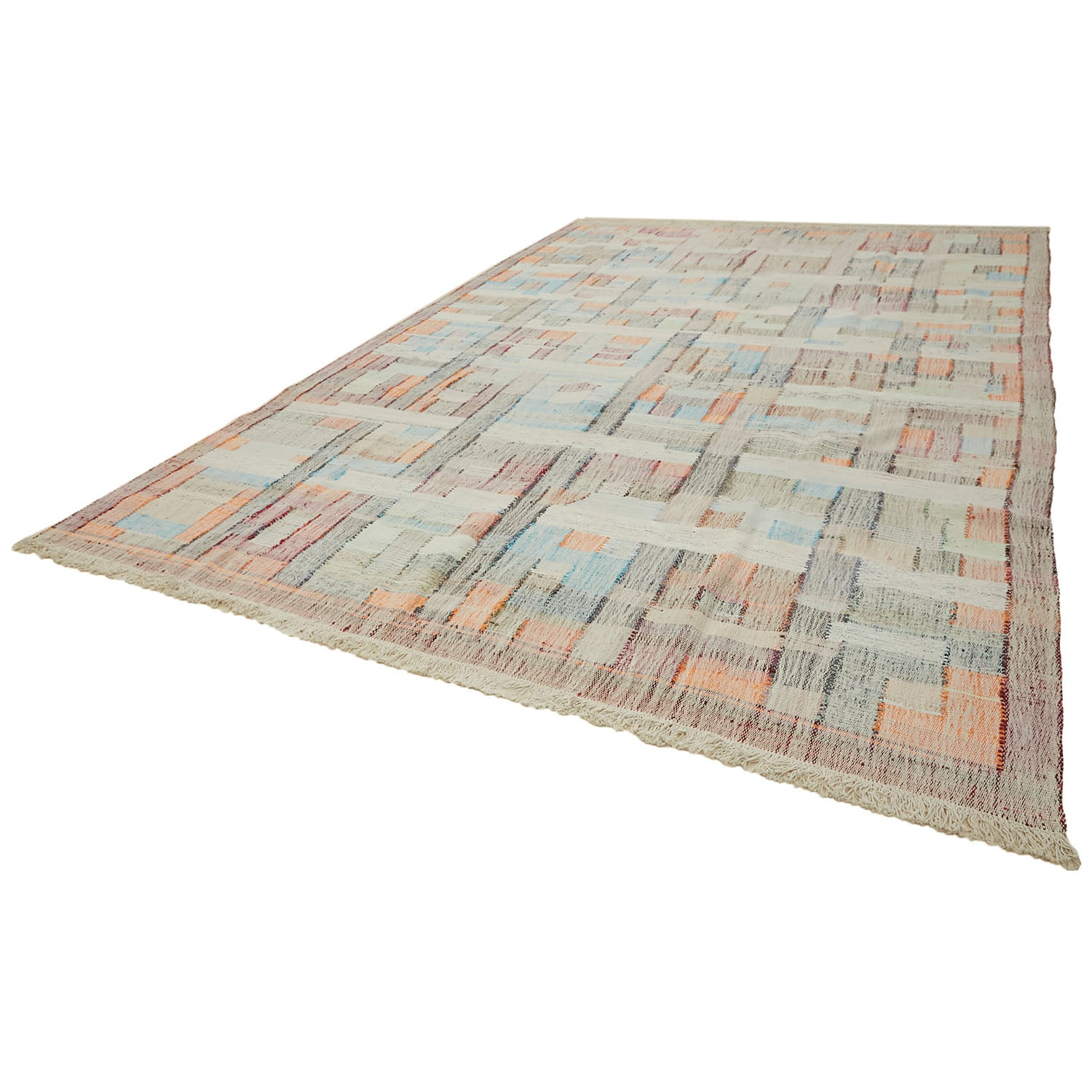 Flat-woven area rug with a pastel patchwork pattern and fringe