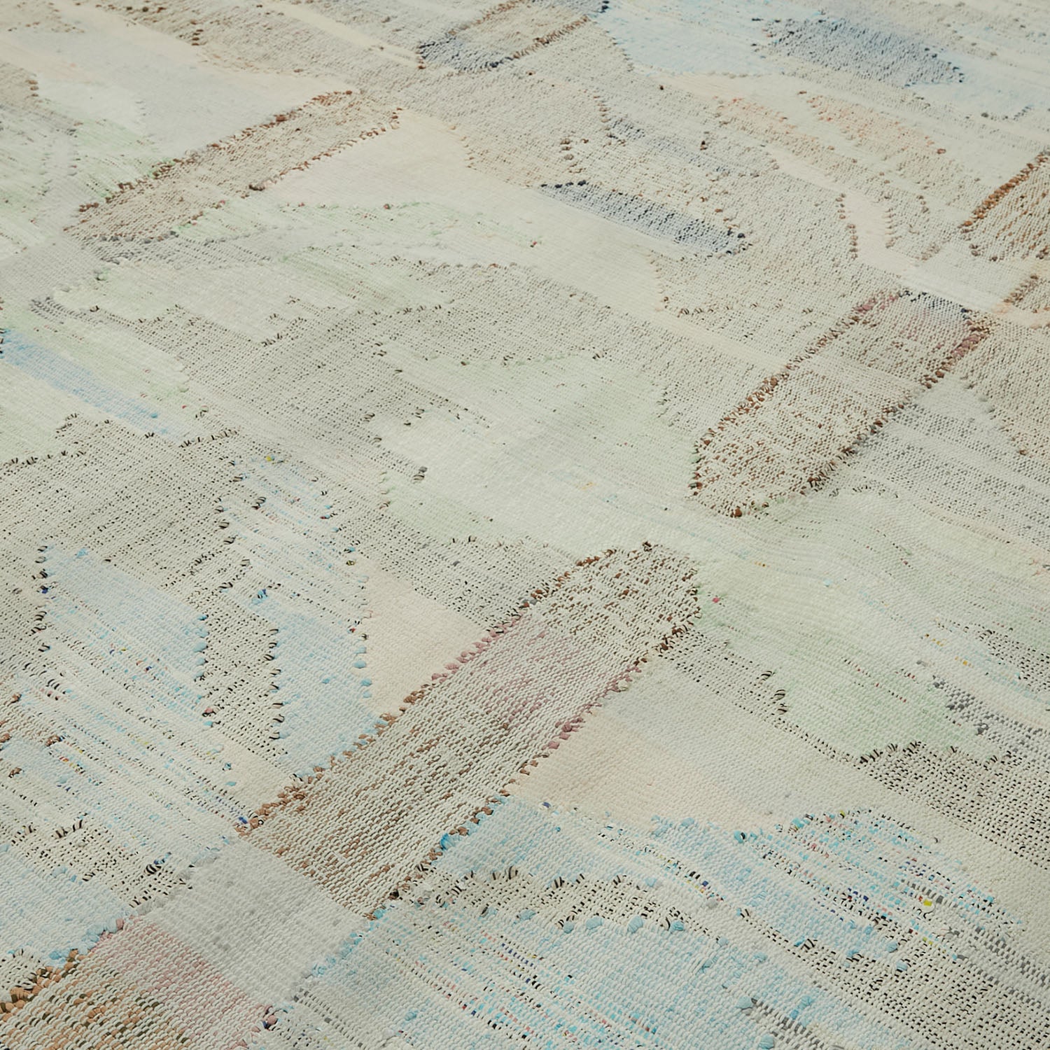 Intricate, sheer lace-like textile with soft pastel variegated pattern.