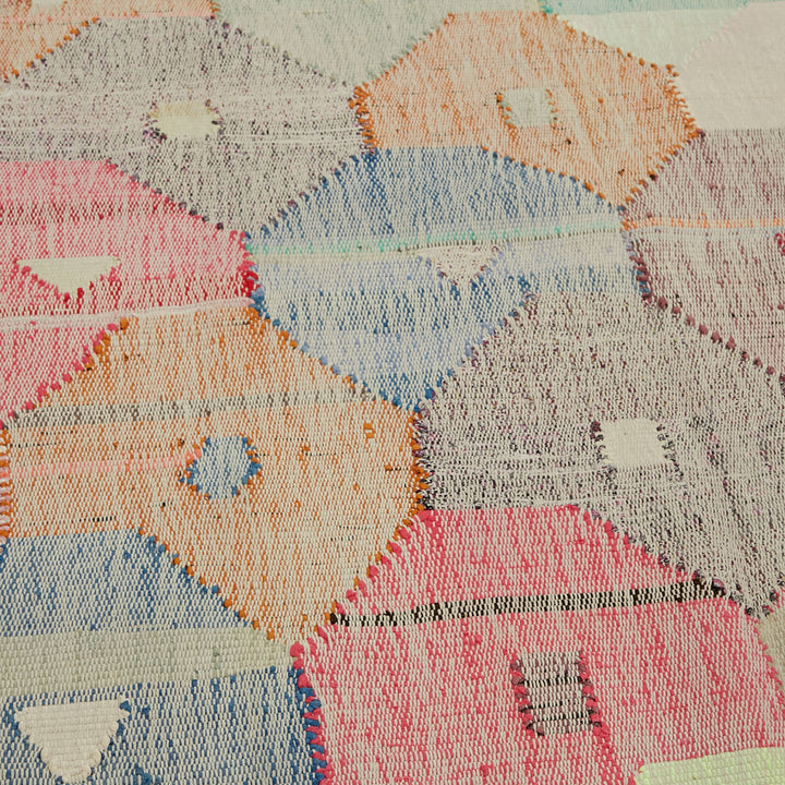 Vibrant, hand-stitched textile showcases intricate hexagonal pattern and varied hues.