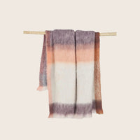 A soft, multicolor striped scarf hanging on a dowel.