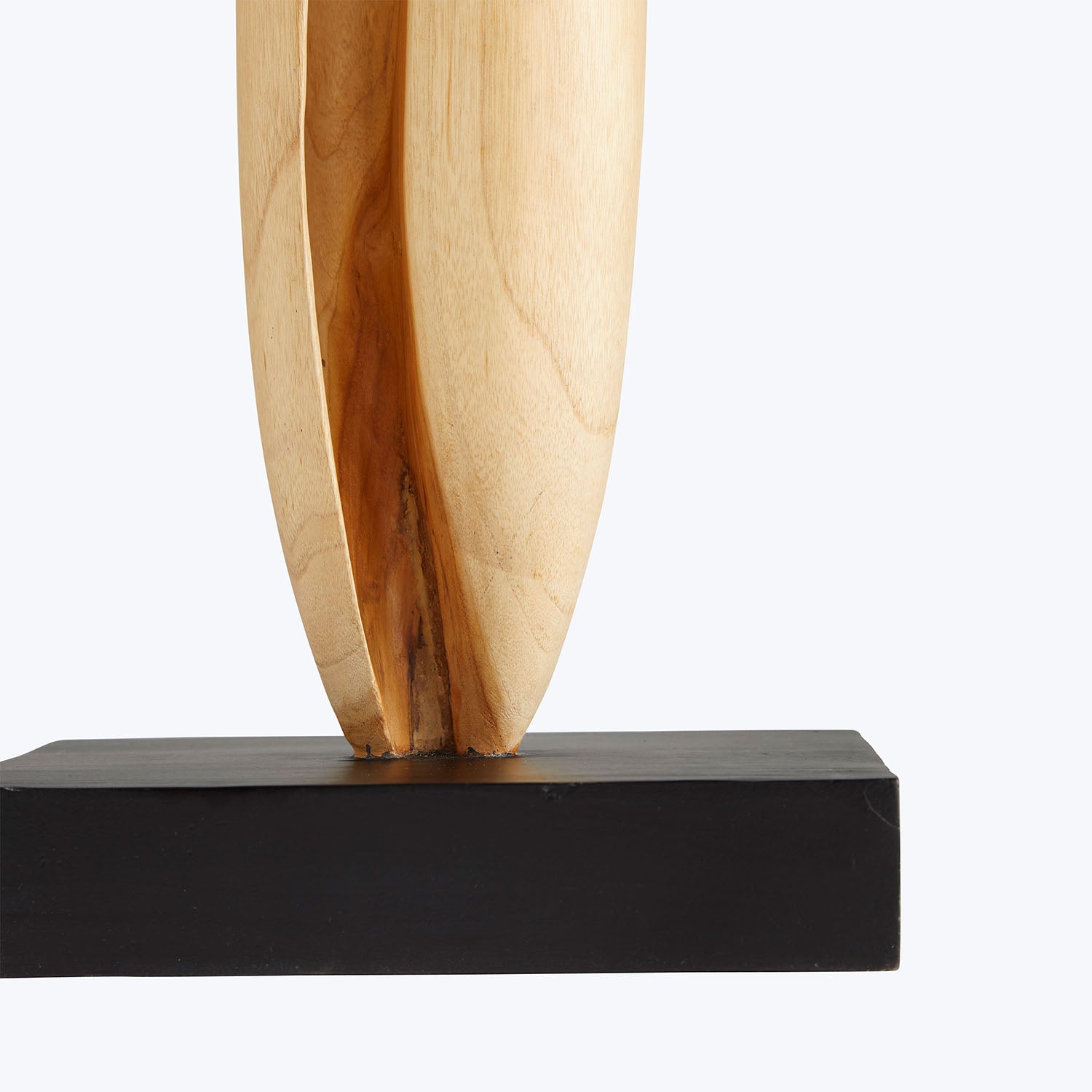Close-up of a beautifully carved wooden sculpture on black base.