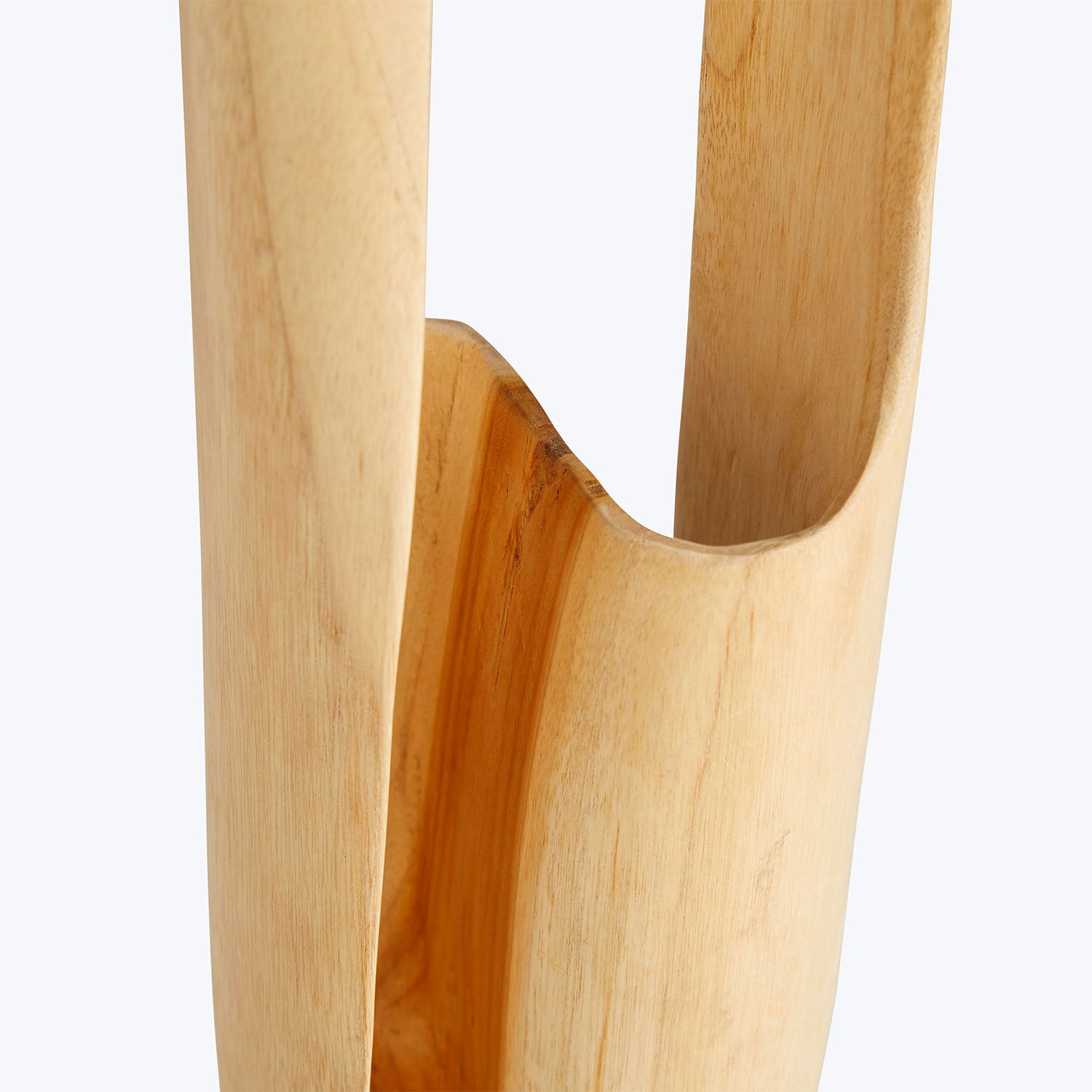 Close-up of a smooth, light-colored wooden object with curved handles.