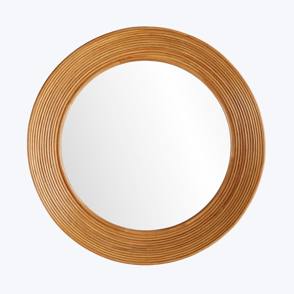 A round mirror with a textured wooden frame reflects bright light.