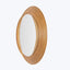 Oval-shaped mirror with textured wood frame adds warmth and elegance.