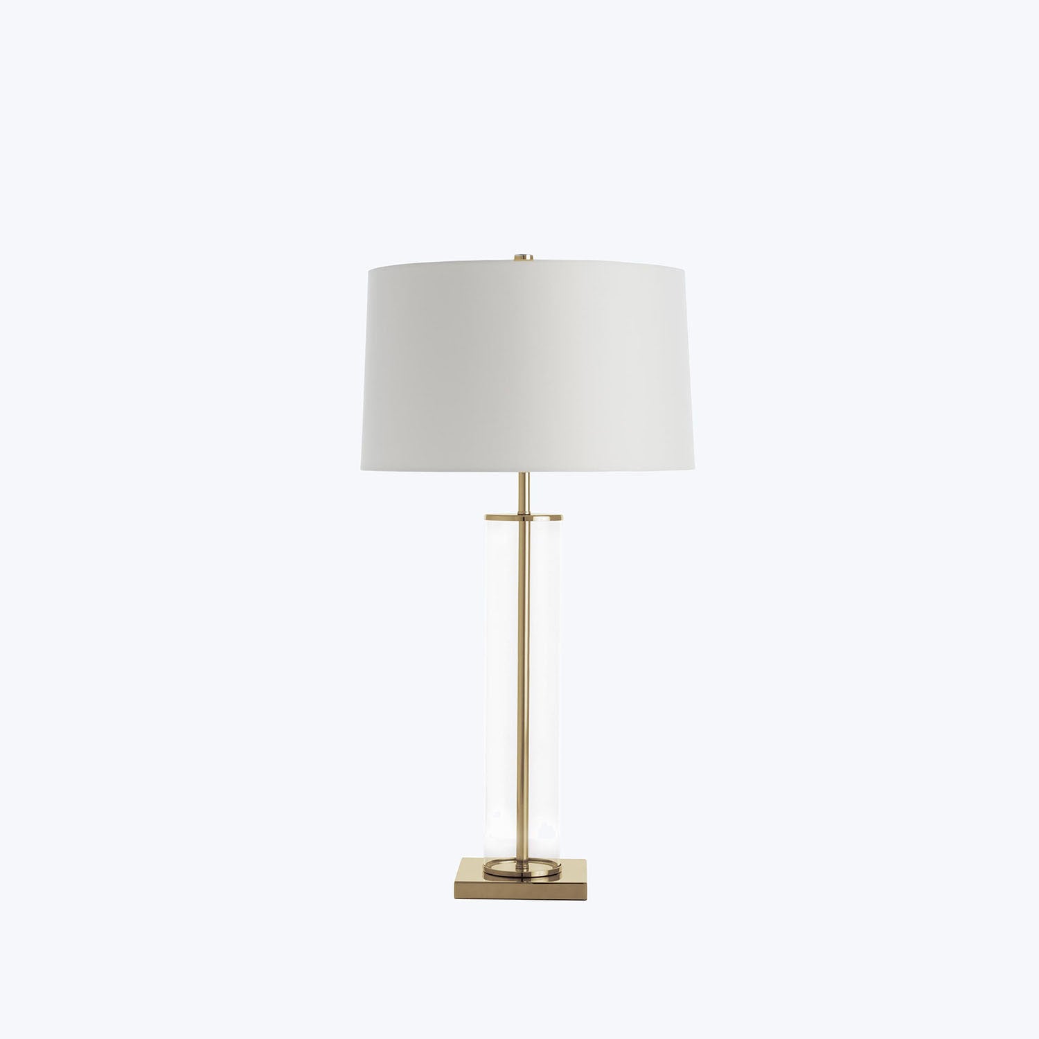 Minimalist table lamp with metallic base, transparent cylinder, and round lampshade.