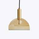 Contemporary half-dome pendant light with hammered textured surface and warm amber glow.