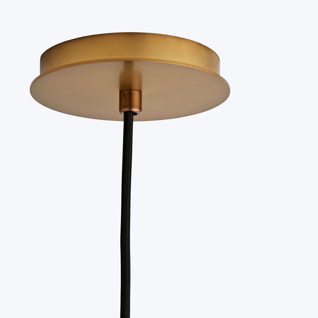 Modern pendant light fixture with golden canopy and black cord.