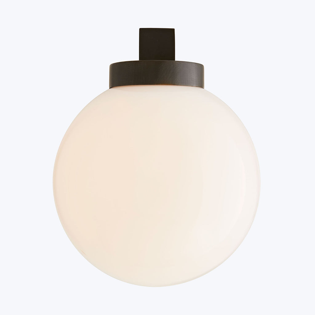 Minimalist spherical light fixture with opaque matte finish emits soft glow.