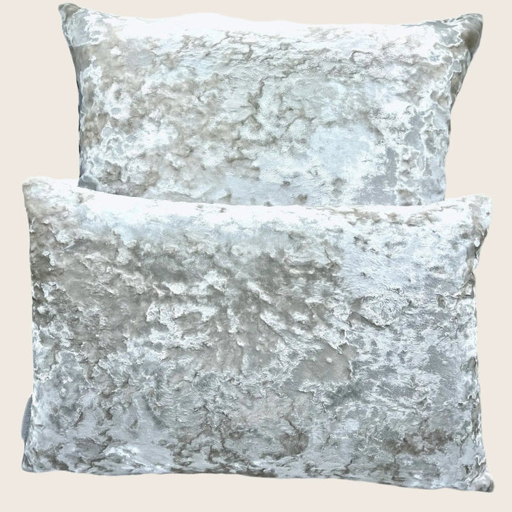 Luxurious decorative pillows with marble-like pattern against plain background.