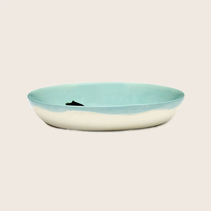 Modern ceramic dish with fish silhouette in two-tone design.