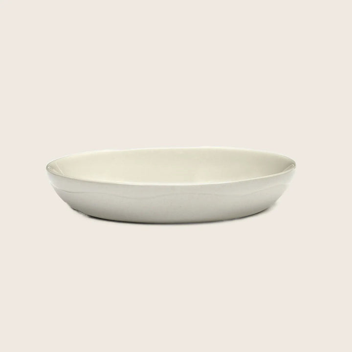 Minimalist oval plate in off-white color against neutral background.