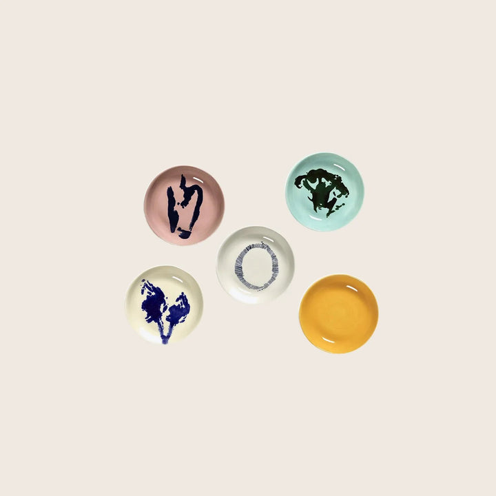 Colorful dishes with global designs arranged in 'X' pattern.
