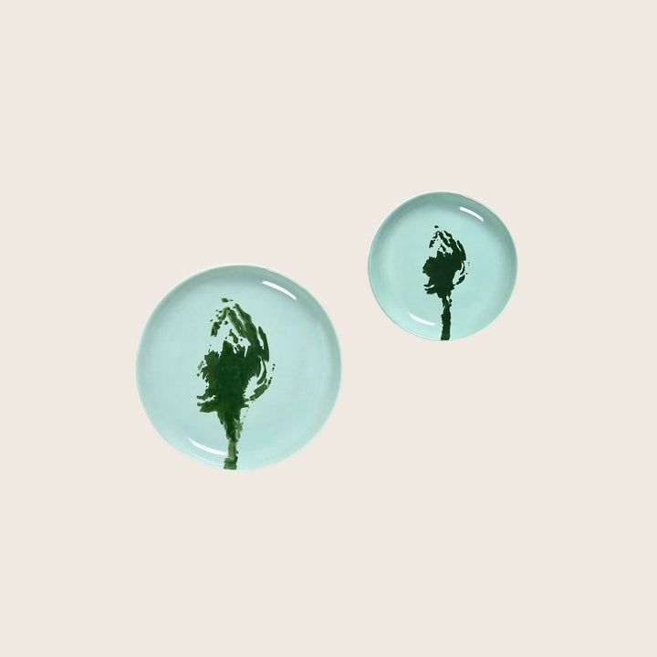 Two turquoise plates with dark green abstract designs. Minimalistic art.