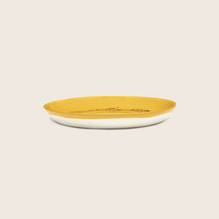 Simple oval dish with yellow interior and white exterior.