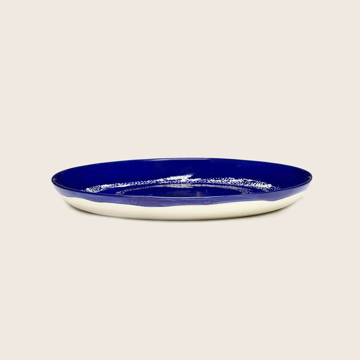 Oval plate with crackled blue glaze and white rim design.