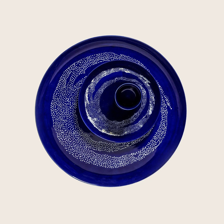Circular cobalt blue glass object with concentric dot design pattern