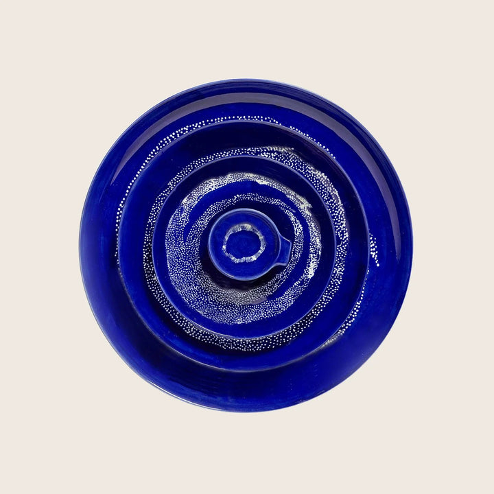 Symmetrical cobalt blue circular art piece on white background