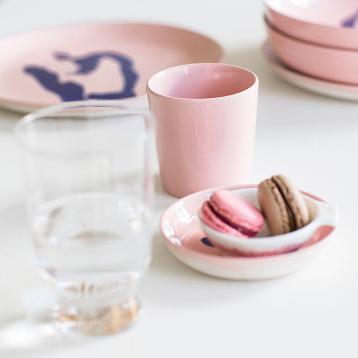 Elegant table setting with pink tableware and assorted food items.