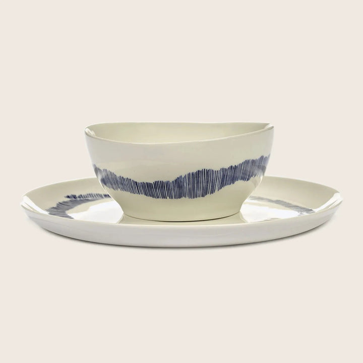 Modern off-white ceramic bowl and plate with blue lines design.