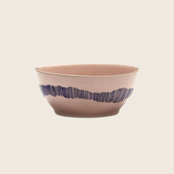Modern beige bowl with blue horizontal pattern on white background.