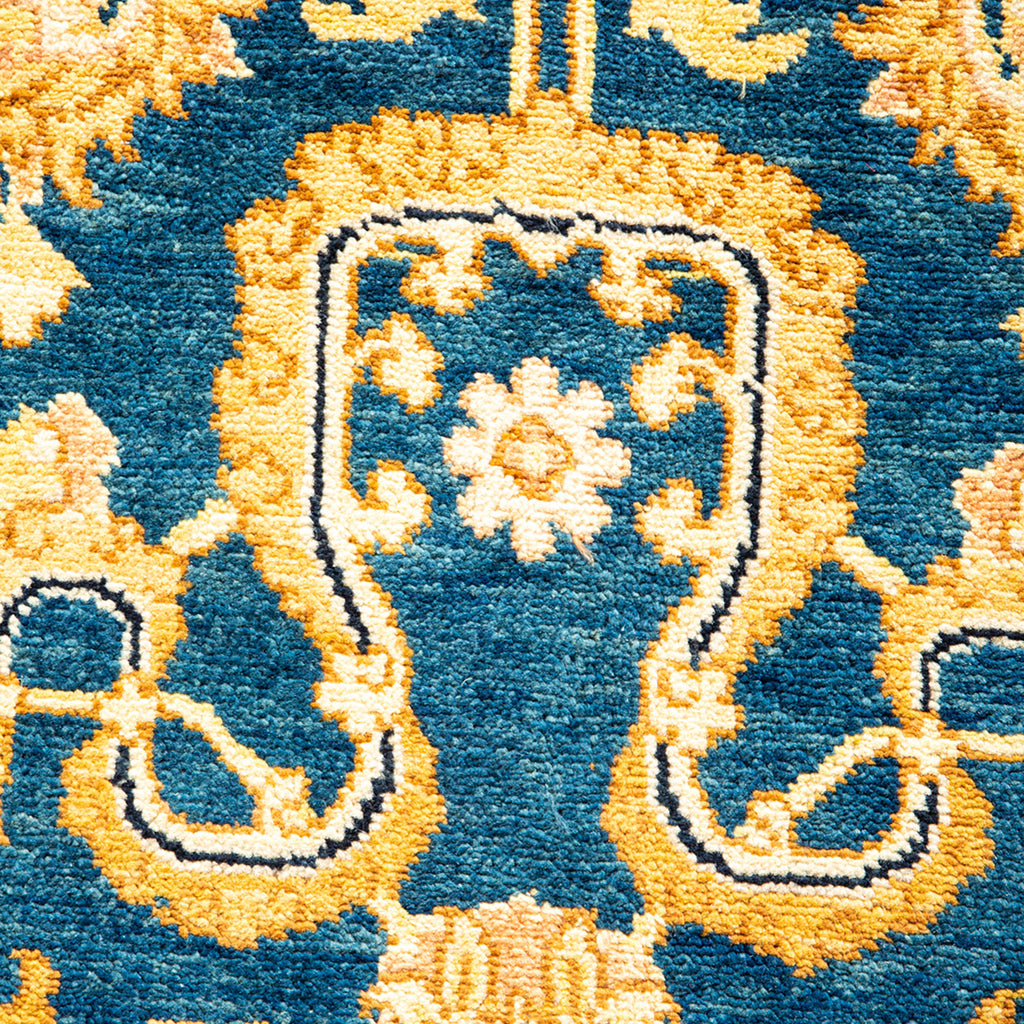 Close-up of an ornate, plush carpet with intricate blue and gold designs.