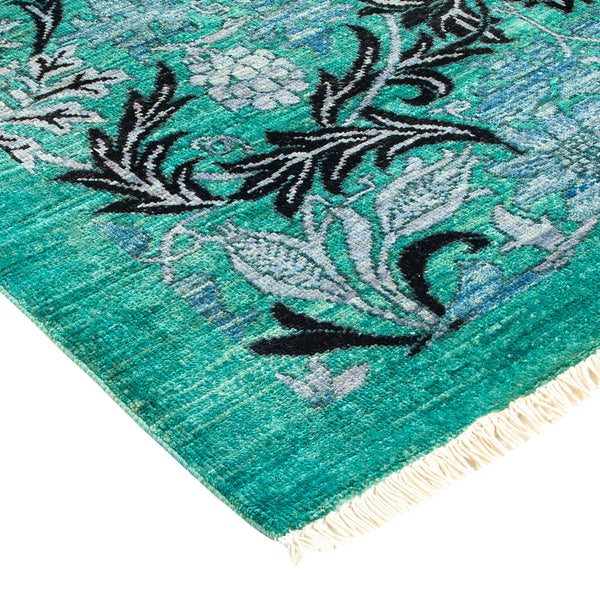Vibrant turquoise corner of ornate floral rug with fringed edges.