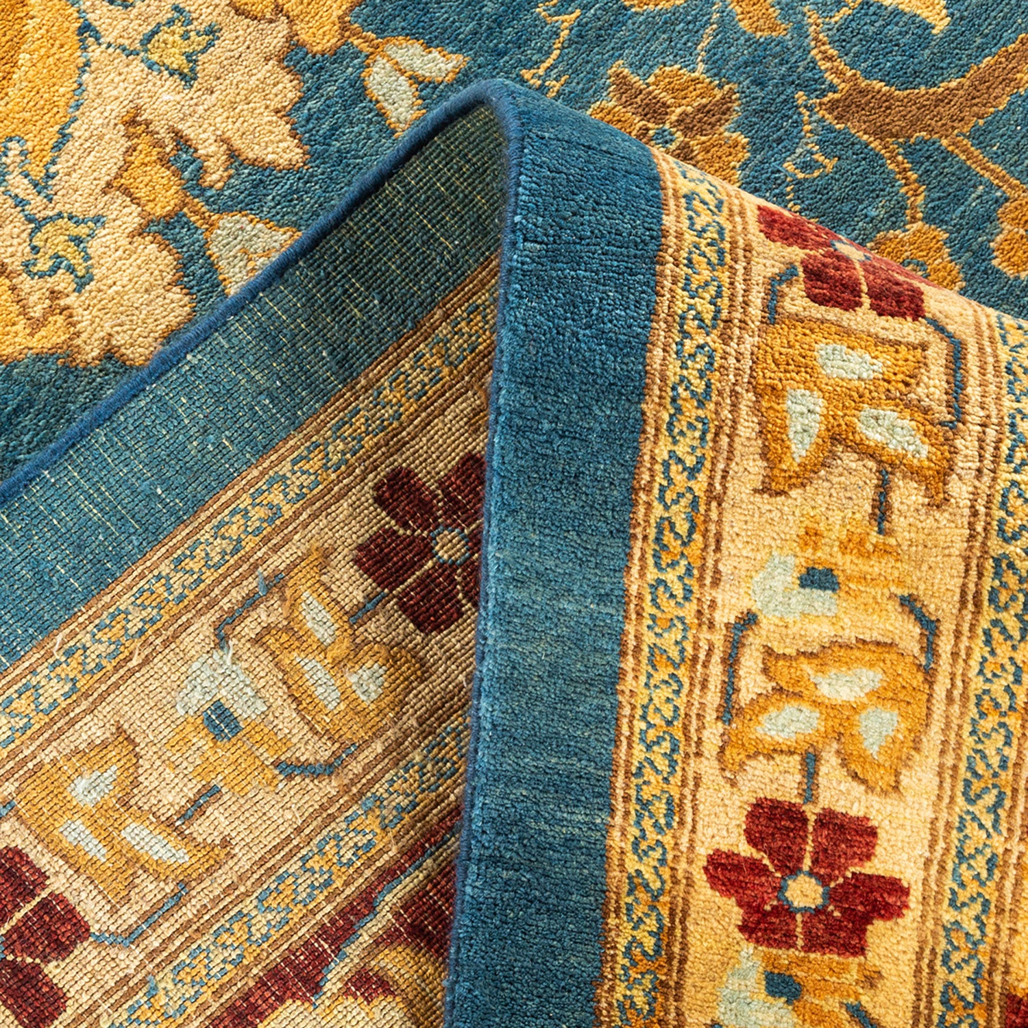 Close-up of two overlapping rugs: plush blue and detailed traditional.