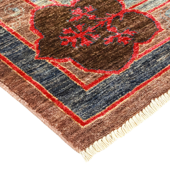Intricate handcrafted rug with geometric and floral patterns in rich colors.
