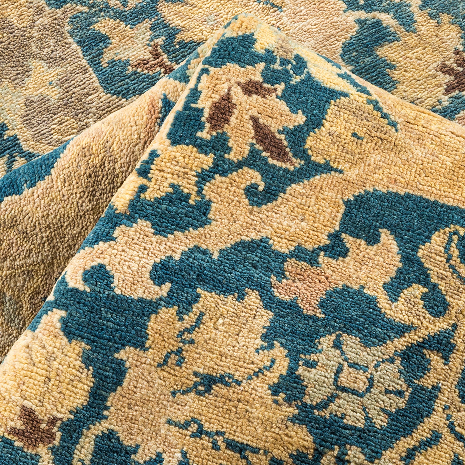 Close-up of a plush, ornate carpet with intricate floral motifs.