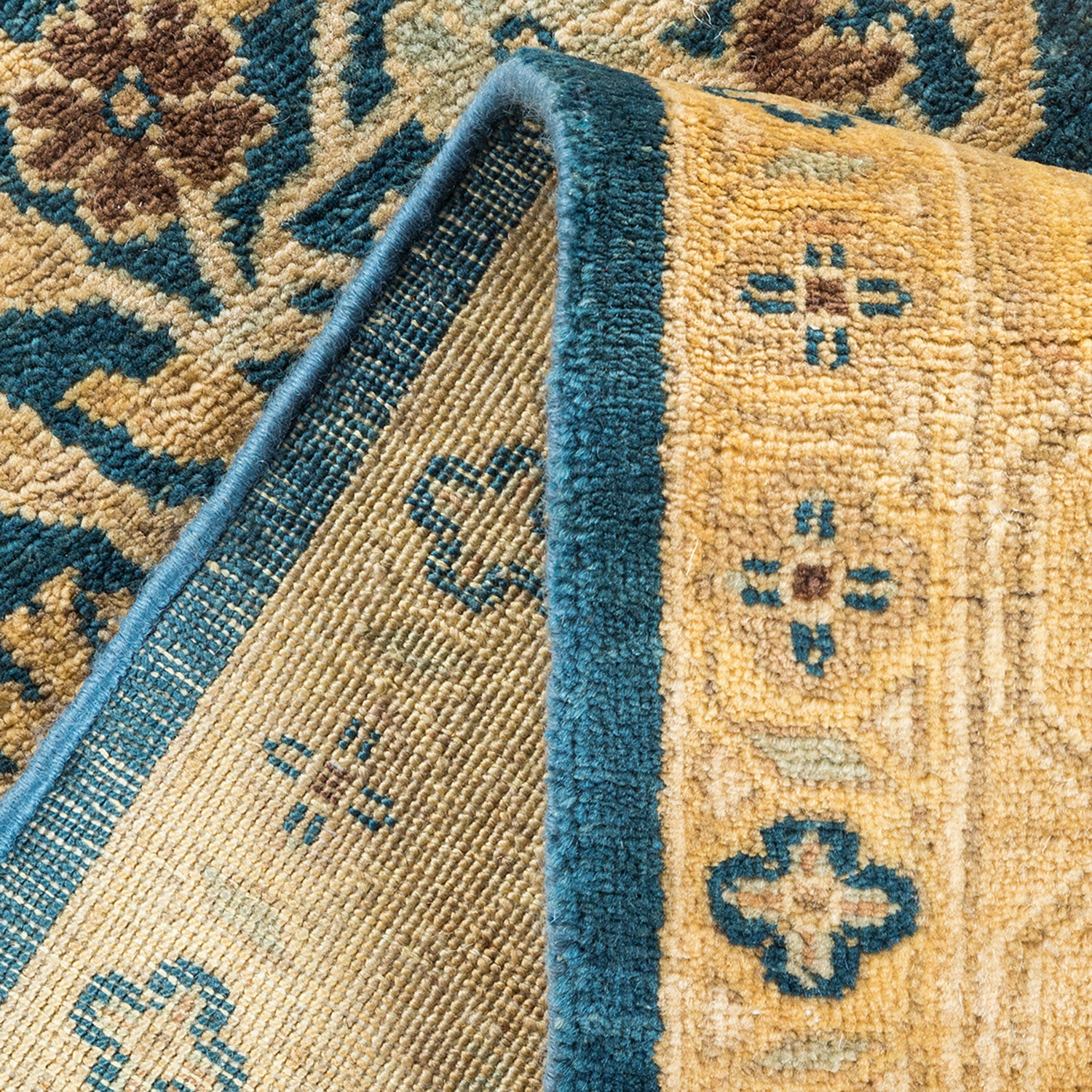Close-up of a folded, patterned textile rug showcasing intricate design
