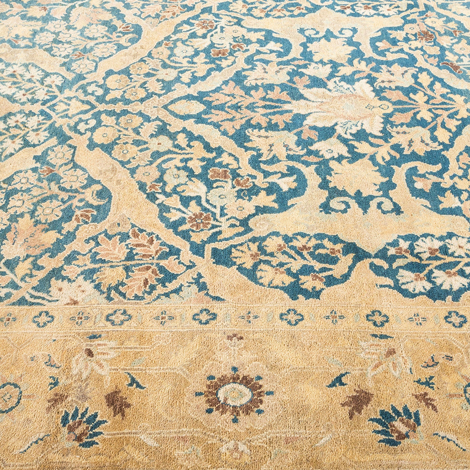 Ornate floral patterned carpet in shades of blue and tan.