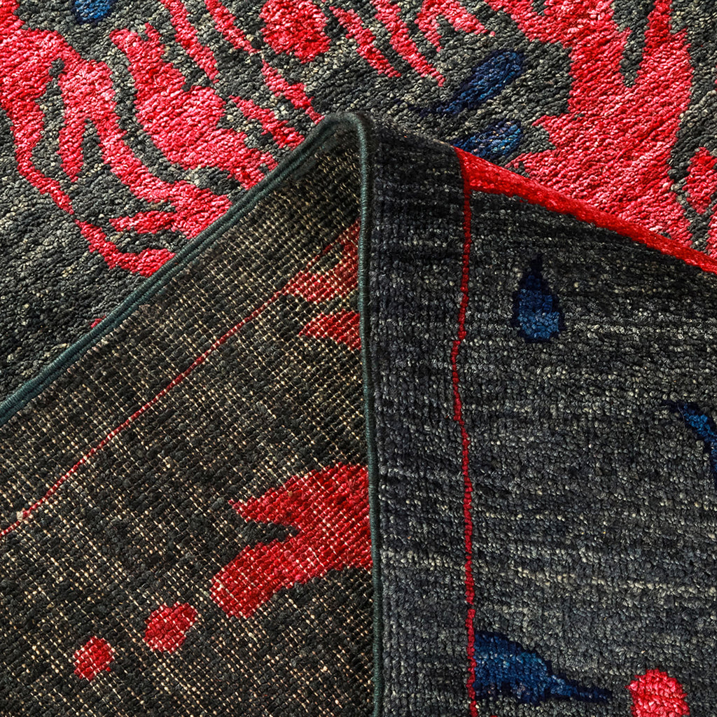 Close-up of fabric with vibrant red and blue floral pattern.